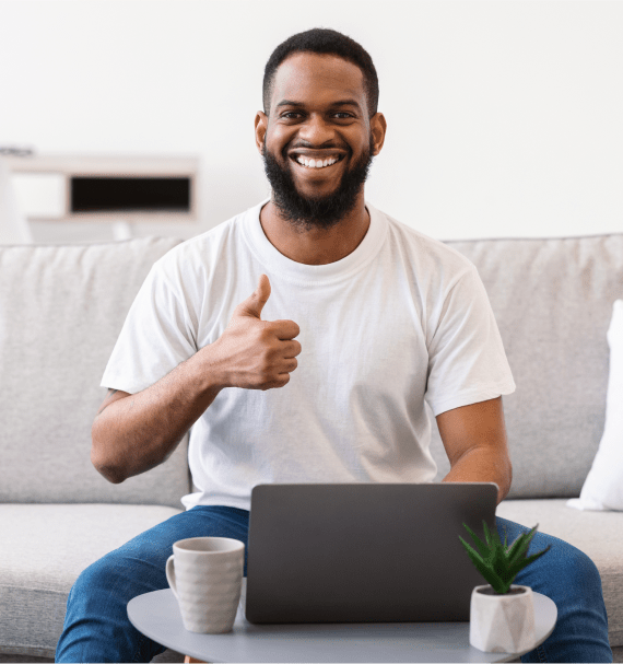 African man at laptop gesturing thumbs up sitting 2023 11 27 05 28 28 utc 1 1