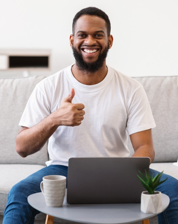 African man at laptop gesturing thumbs up sitting 2023 11 27 05 28 28 utc 1