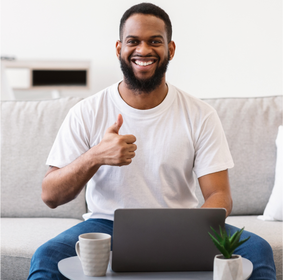African man at laptop gesturing thumbs up sitting 2023 11 27 05 28 28 utc 1 2